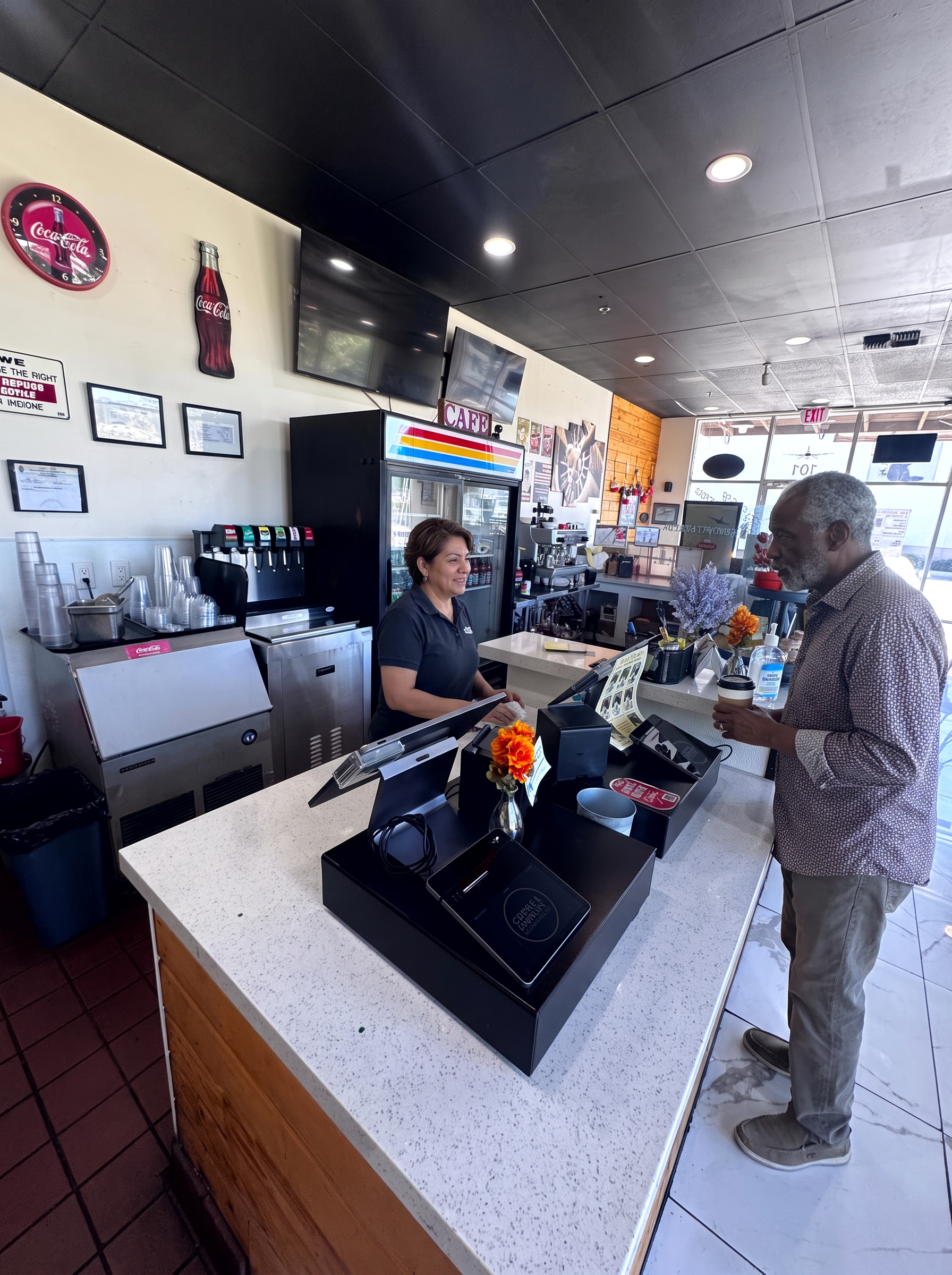 A cafe team member serving a guest a coffee at the register